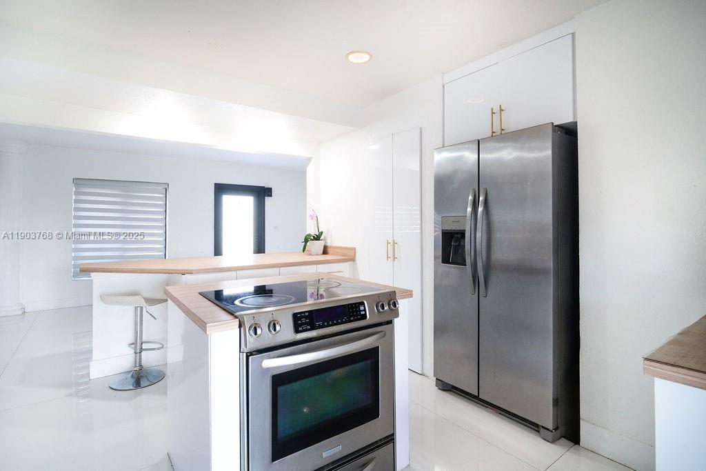 1960 Southwest 128th Court Miami, FL 33175 - Photo 17 of 32 a kitchen with stainless steel appliances granite countertop a stove a refrigerator and a sink with wooden floor