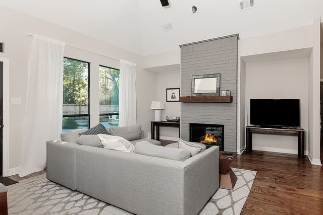 a living room with furniture a fireplace and a flat screen tv