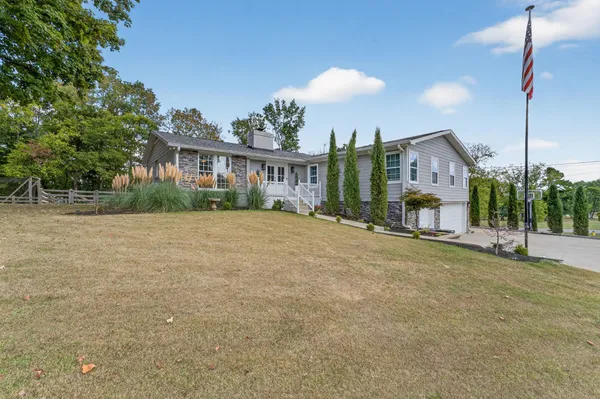 a front view of a house with a yard and potted plants