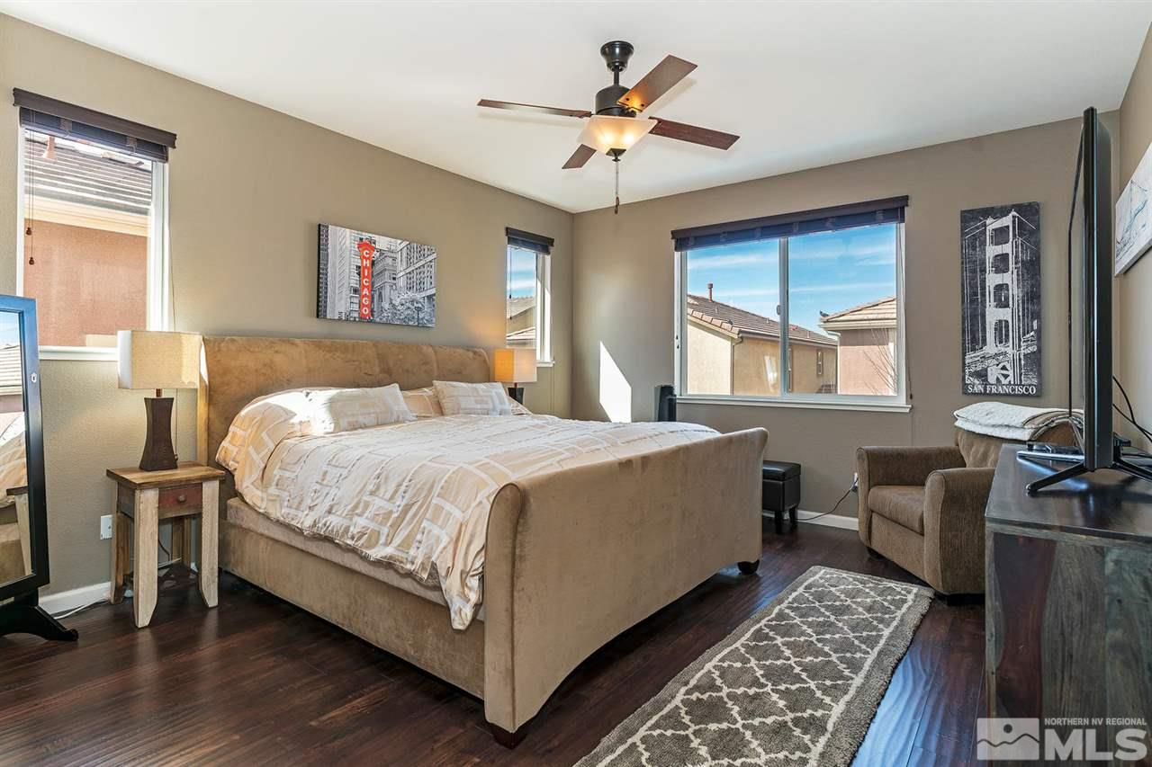 1965 Hope Valley Drive Reno, NV 89521 - Photo 8 of 17 a bedroom with a large bed a chandelier and windows