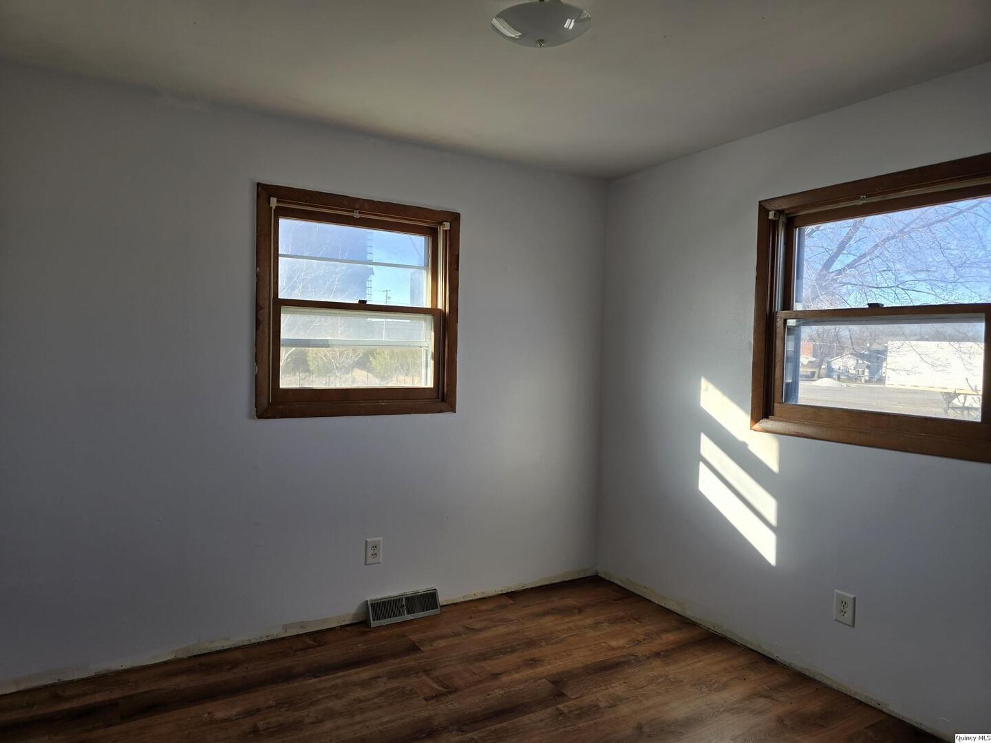 305 East 3rd Street Bowen, IL 62316 - Photo 12 of 32 an empty room with wooden floor and windows