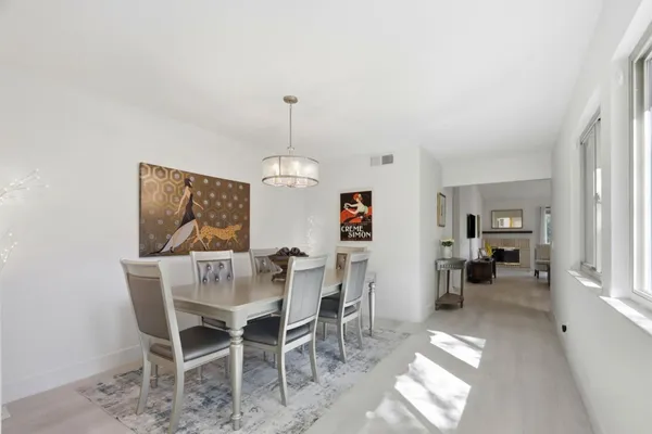 a view of a dining room and livingroom with furniture wooden floor a chandelier