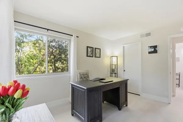 a bedroom with a bed and a flat tv screen on the dresser