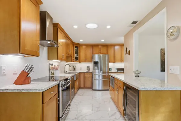 a kitchen with stainless steel appliances granite countertop sink stove and refrigerator