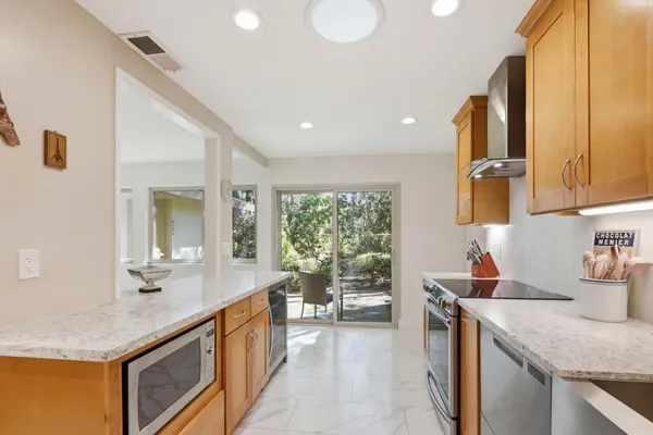 a kitchen with stainless steel appliances granite countertop a sink and a refrigerator