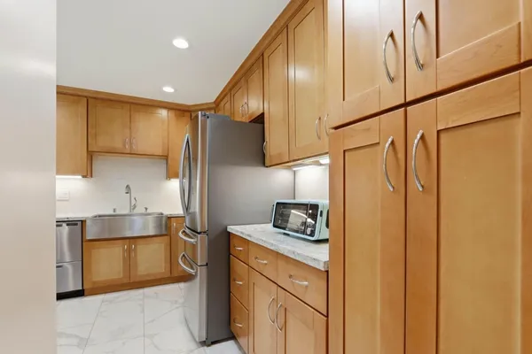 a kitchen with stainless steel appliances granite countertop a sink a stove and a refrigerator