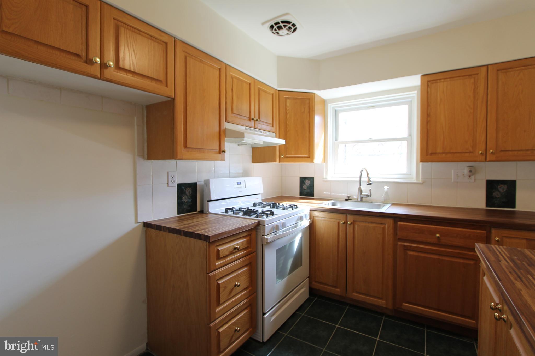 8244 Woolston Avenue Philadelphia, PA 19150 - Photo 13 of 19 a kitchen with stainless steel appliances granite countertop a sink stove and cabinets