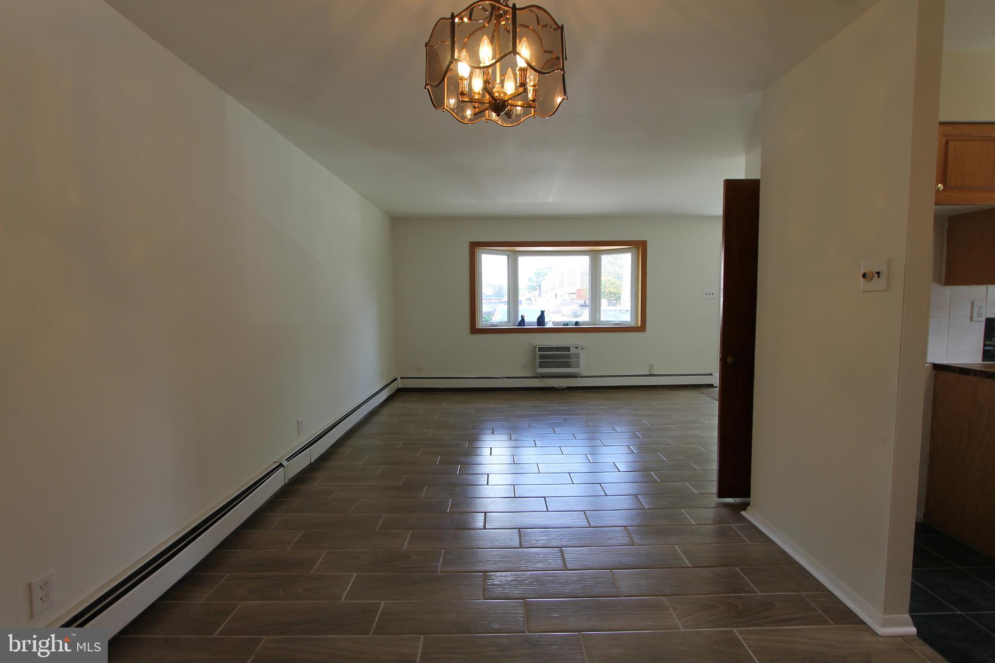 8244 Woolston Avenue Philadelphia, PA 19150 - Photo 7 of 19 wooden floor in an empty room with a window