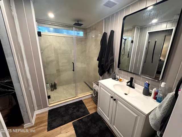 a bathroom with a sink a toilet a mirror and shower