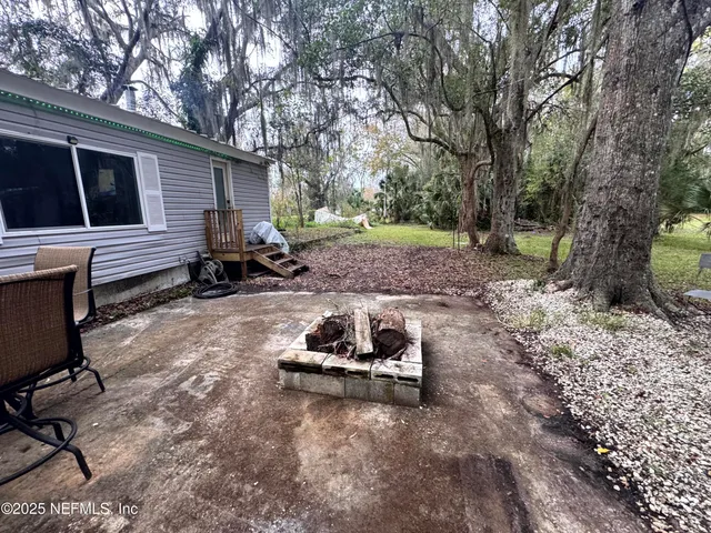 a backyard of a house with barbeque oven table and chairs