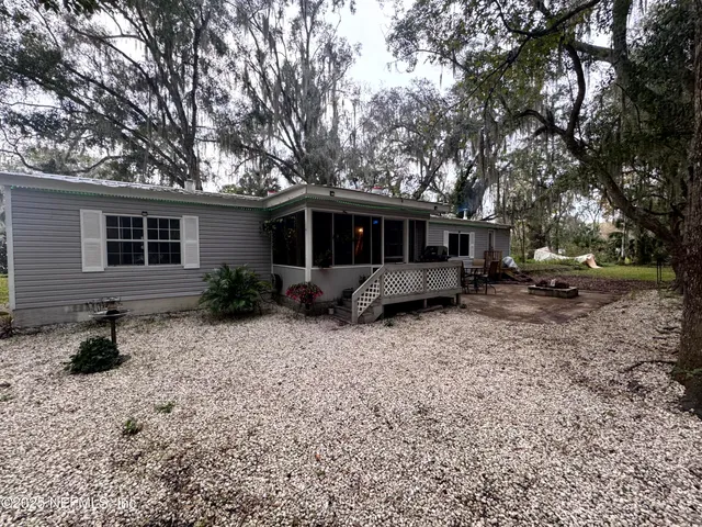 a view of a house with backyard and sitting area
