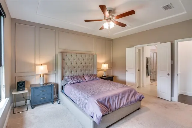 a spacious bedroom with a large bed a chandelier and a large window