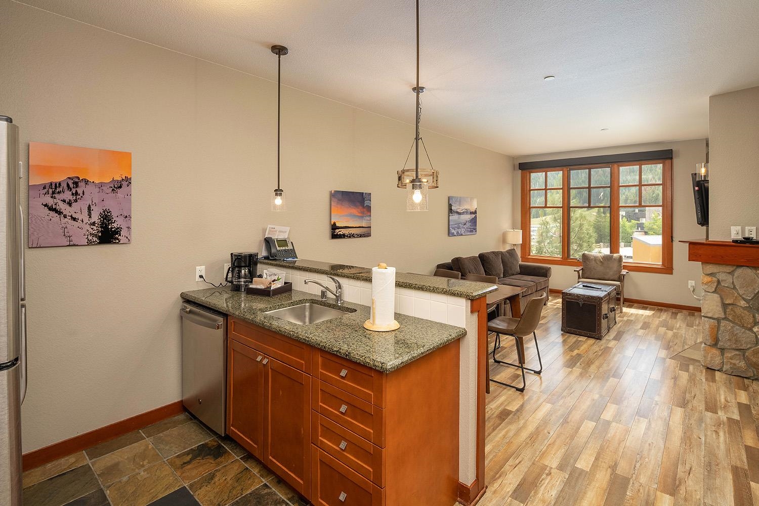 a view of kitchen island with stainless steel appliances granite countertop sink stove and wooden floor