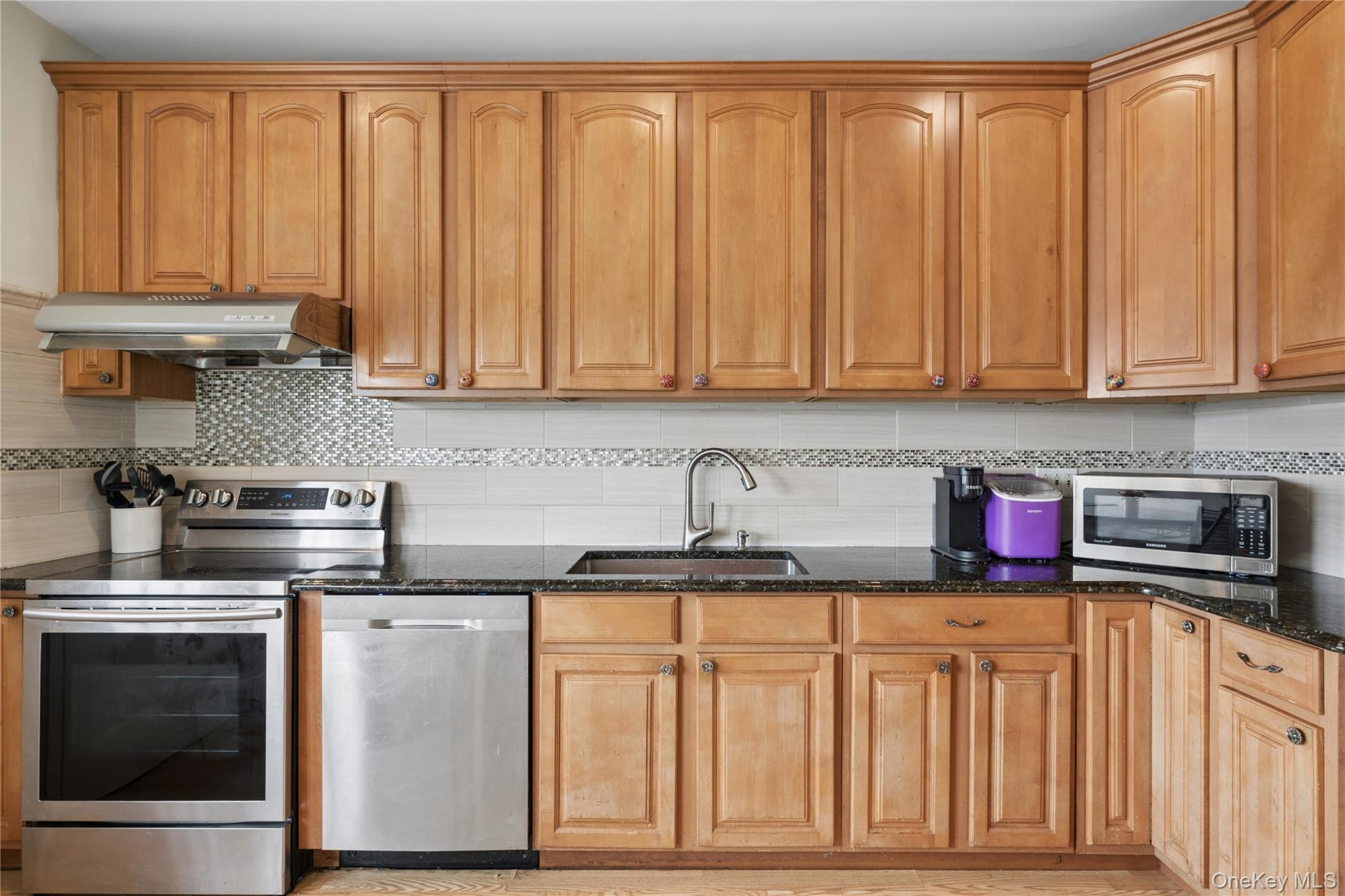 40 Scholar Lane Commack, NY 11725 - Photo 14 of 49 a kitchen with stainless steel appliances granite countertop a stove a sink dishwasher and cabinets with wooden floor
