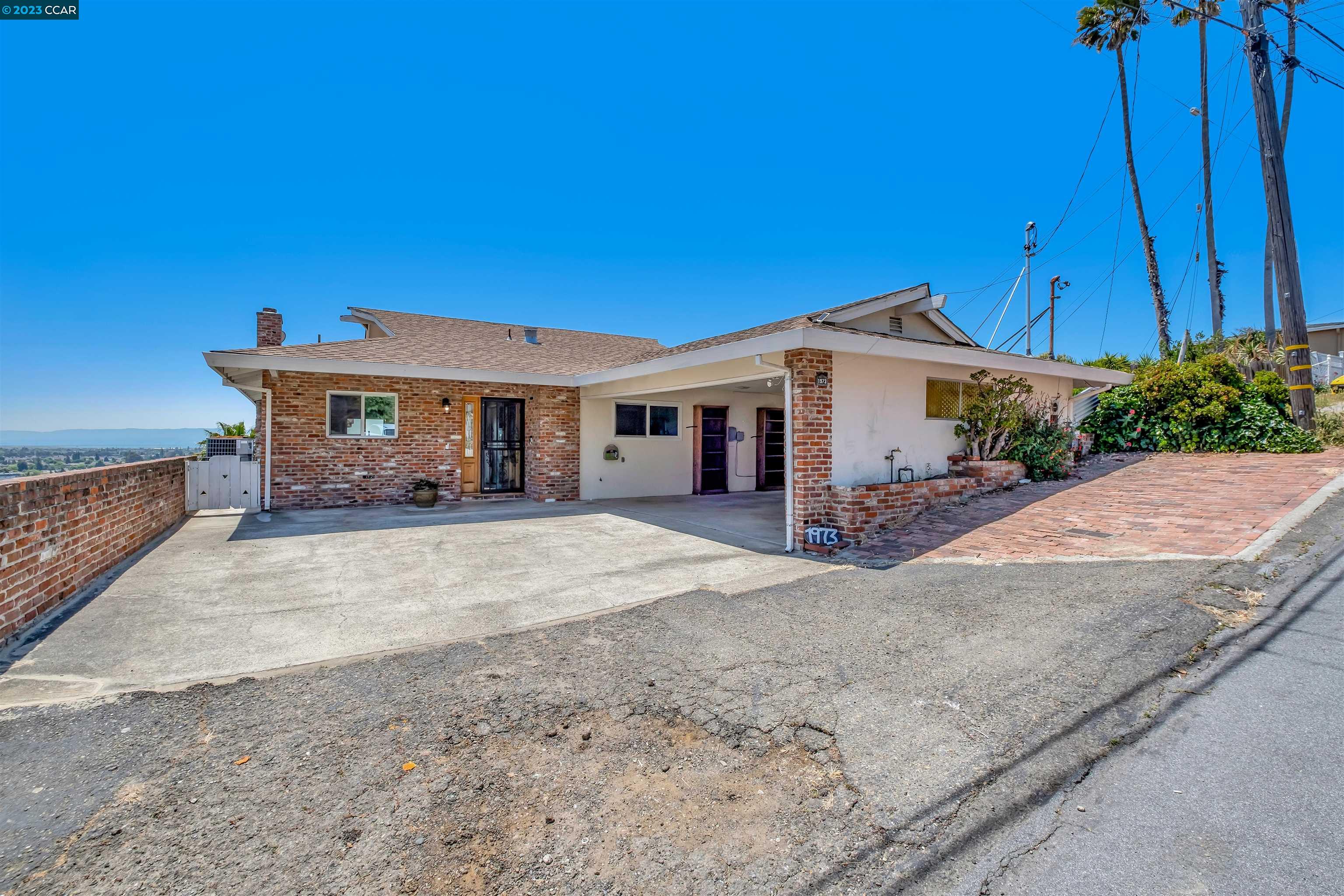 a view of a house with backyard and sitting area