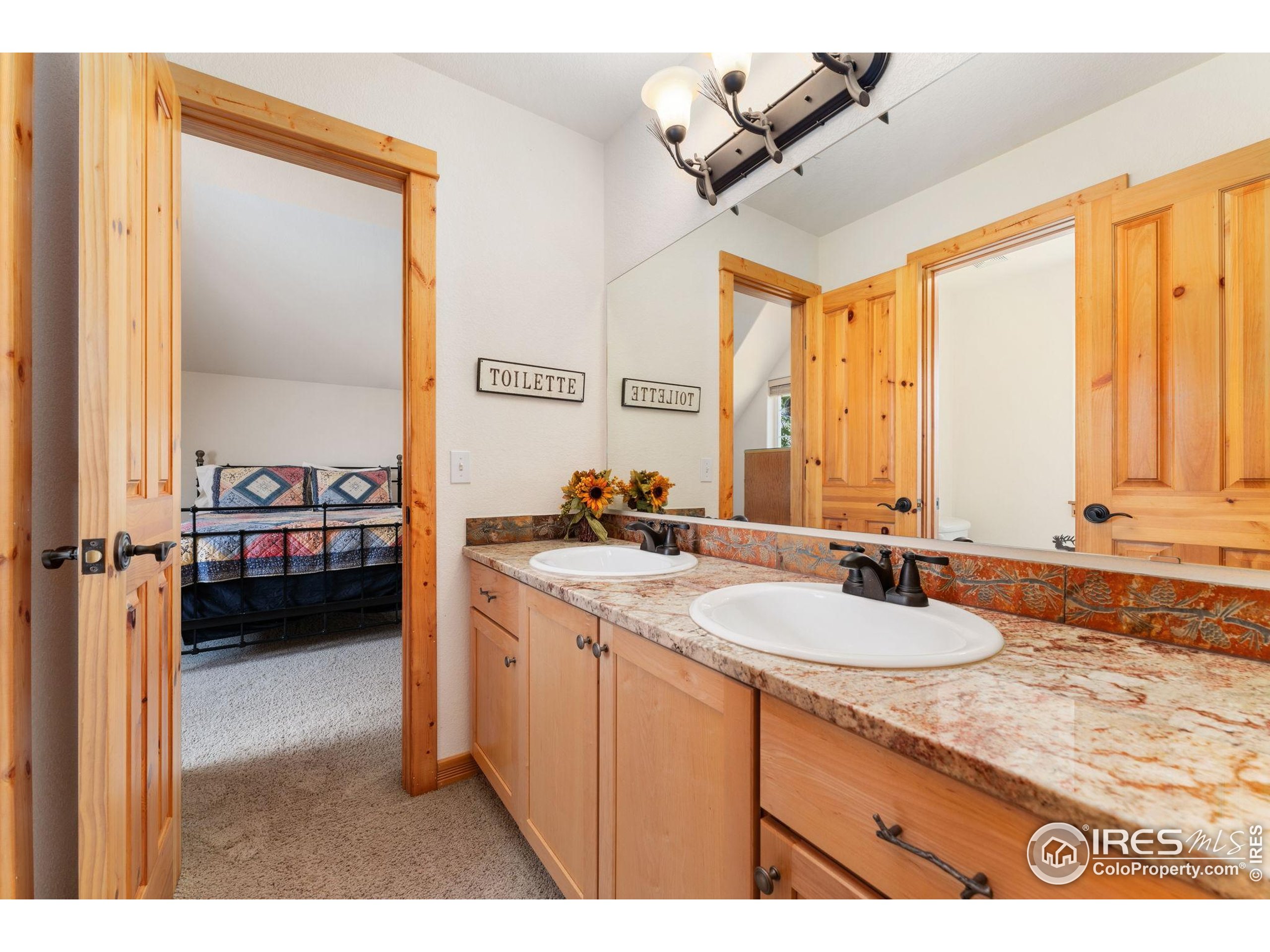 3302 Rinn Valley Drive Longmont, CO 80504 - Photo 25 of 45 a en suite bathroom with a double vanity sink and mirror