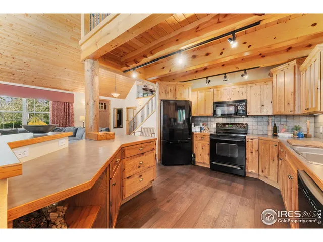 a living room with stainless steel appliances kitchen island granite countertop furniture and a large window