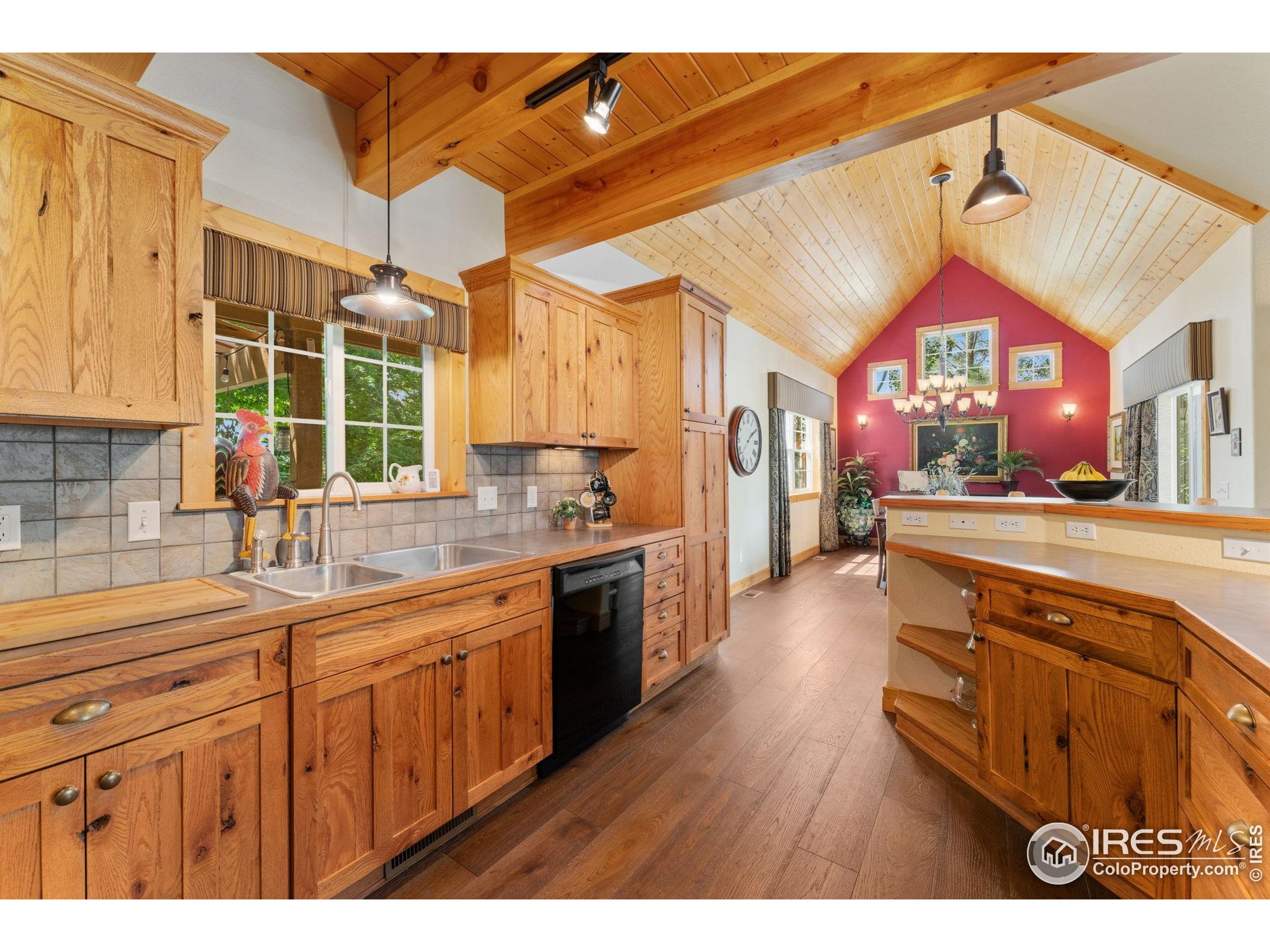 3302 Rinn Valley Drive Longmont, CO 80504 - Photo 10 of 45 a kitchen with kitchen island granite countertop a sink cabinets and wooden floor