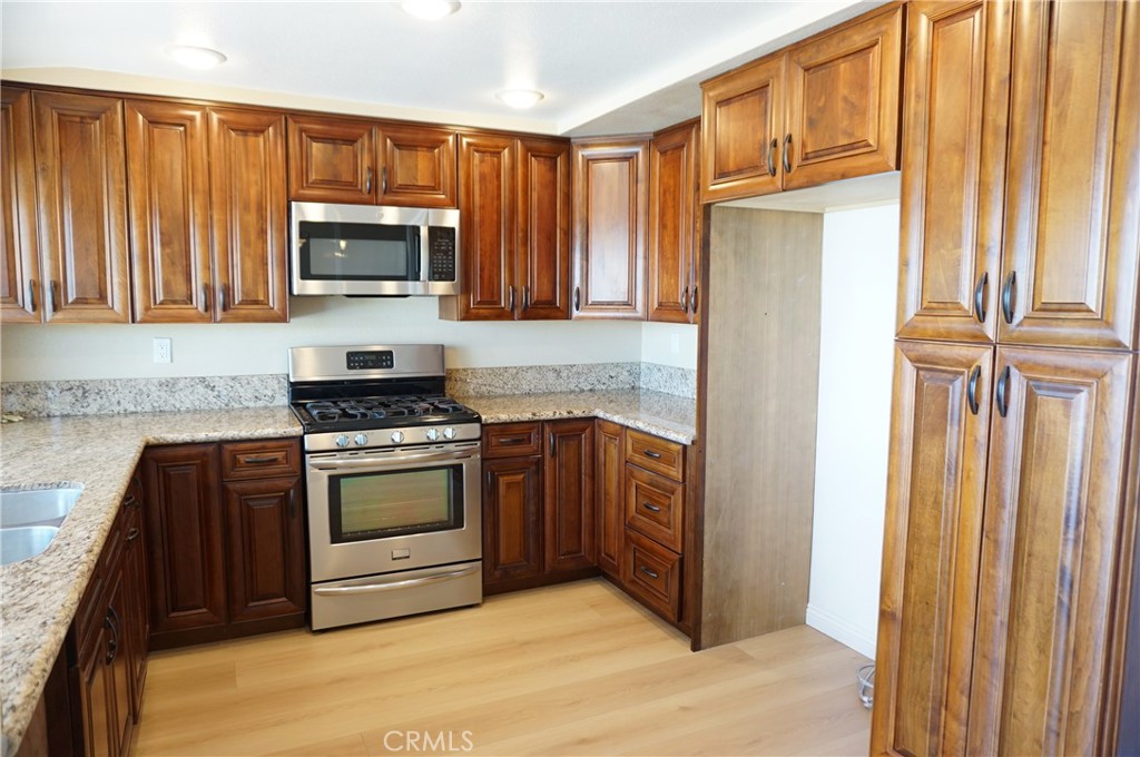 19584 Shadow Glen Circle Porter Ranch, CA 91326 - Photo 11 of 72 a kitchen with stainless steel appliances granite countertop a refrigerator and a stove top oven