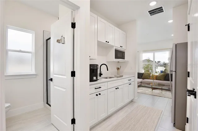 a large white kitchen with cabinets