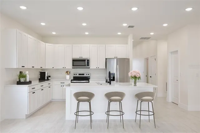 a kitchen with white cabinets and stainless steel appliances