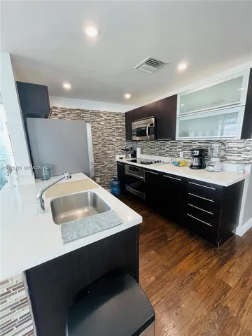 a kitchen with sink a microwave a stove and refrigerator