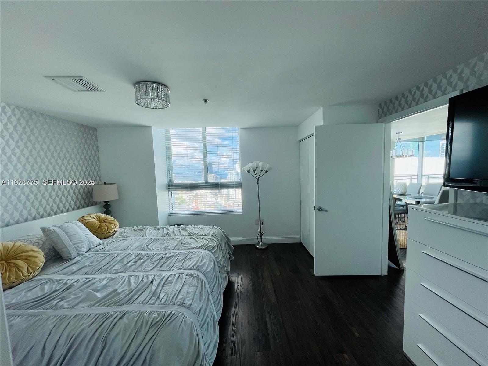 90 Southwest 3rd Street, Unit 4404 Miami, FL 33130 - Photo 13 of 28 a bedroom with a bed and a television in it