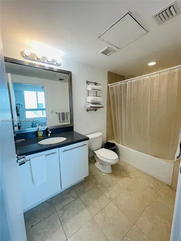 a bathroom with a double vanity sink toilet and a mirror