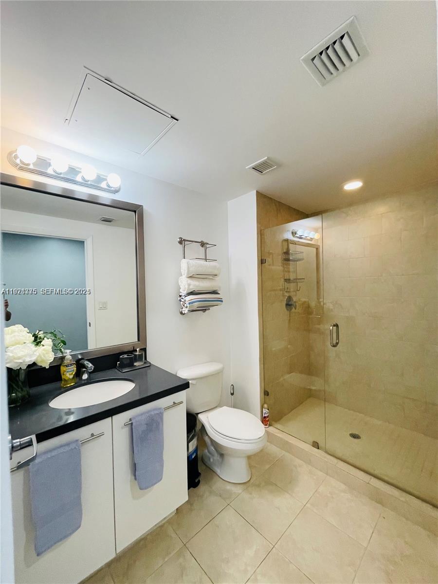90 Southwest 3rd Street, Unit 4404 Miami, FL 33130 - Photo 18 of 28 a bathroom with a granite countertop sink a toilet a mirror and shower