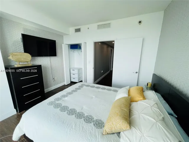 a bedroom with a bed and a flat screen tv