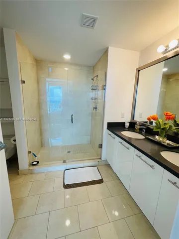 a bathroom with a granite countertop sink a toilet and a mirror