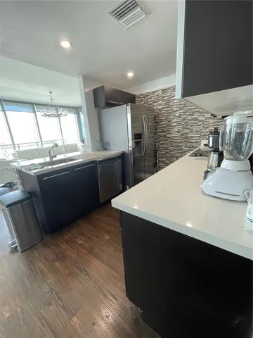a kitchen with stainless steel appliances kitchen island granite countertop a sink and a stove