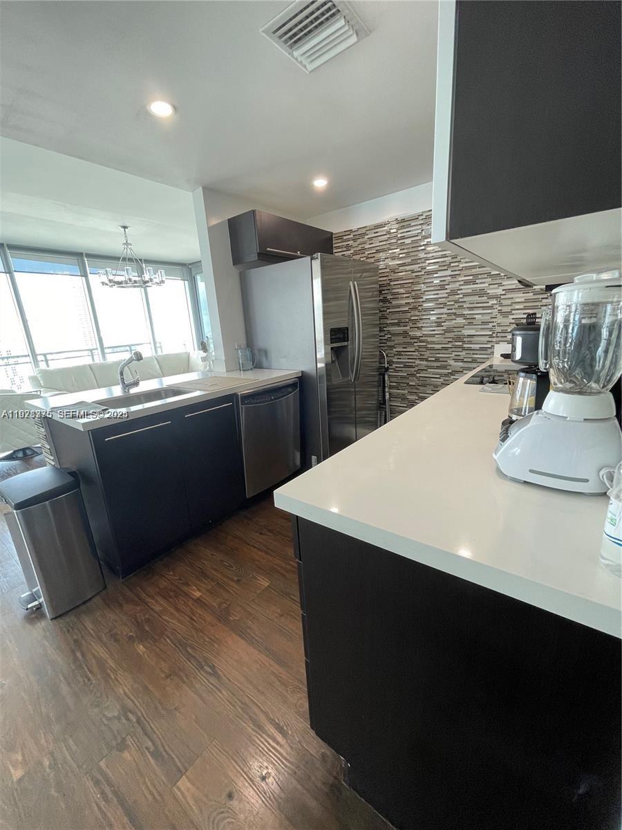 90 Southwest 3rd Street, Unit 4404 Miami, FL 33130 - Photo 4 of 28 a kitchen with stainless steel appliances kitchen island granite countertop a sink and a stove