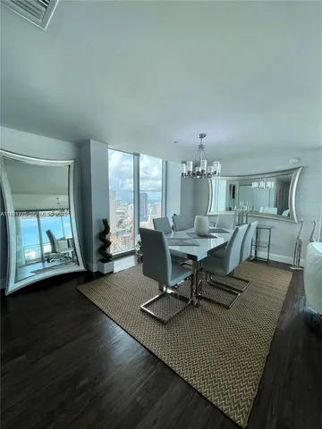 a living room with furniture a rug potted plant and a large window