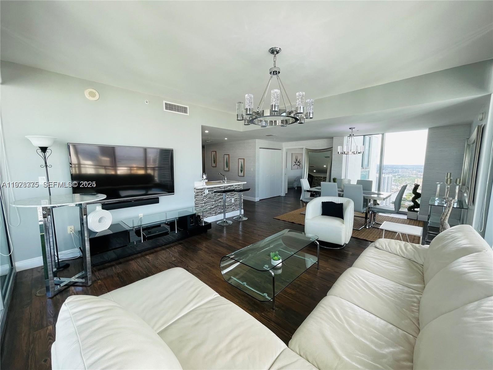 90 Southwest 3rd Street, Unit 4404 Miami, FL 33130 - Photo 10 of 28 a living room with furniture and a flat screen tv