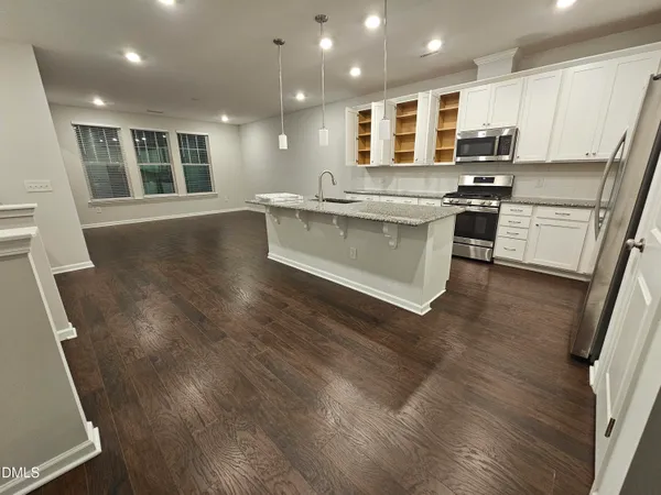 a large kitchen with stainless steel appliances granite countertop a stove a sink and a refrigerator