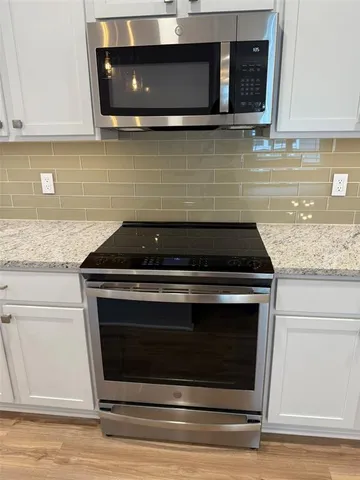 a kitchen with granite countertop wood cabinets and stainless steel appliances