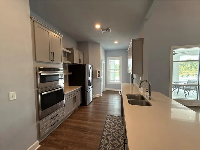 a kitchen with stainless steel appliances a microwave a sink and cabinets