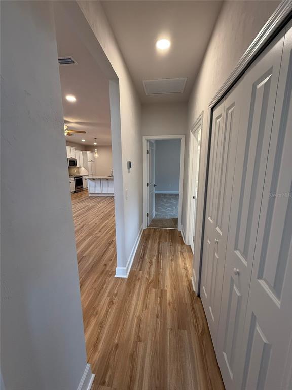 9654 Southwest 67th Lane Gainesville, FL 32608 - Photo 6 of 44 a view of a hallway with wooden floor and staircase
