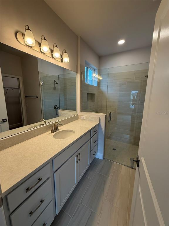 9654 Southwest 67th Lane Gainesville, FL 32608 - Photo 9 of 44 a bathroom with a double vanity sink and mirror with shower