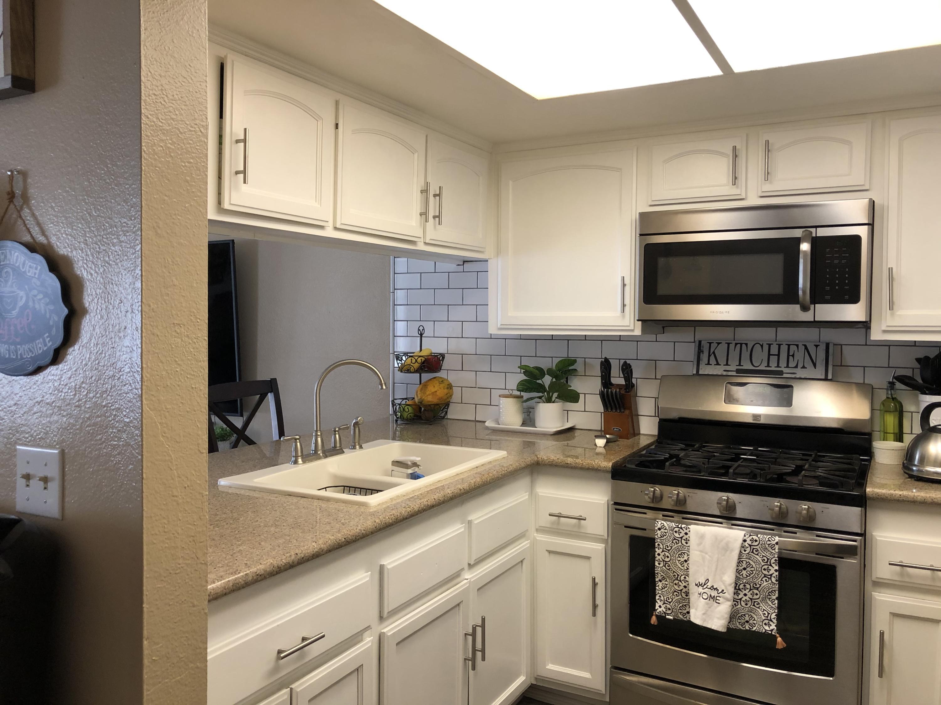 352 East Bard Road Oxnard, CA 93033 - Photo 10 of 26 a kitchen with stainless steel appliances granite countertop a stove a microwave and a sink