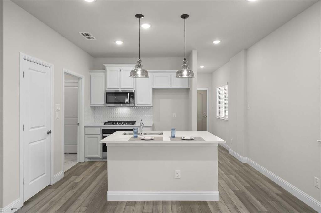 203 Griffith Drive Princeton, TX 75407 - Photo 14 of 15 a kitchen with kitchen island a sink stainless steel appliances and cabinets