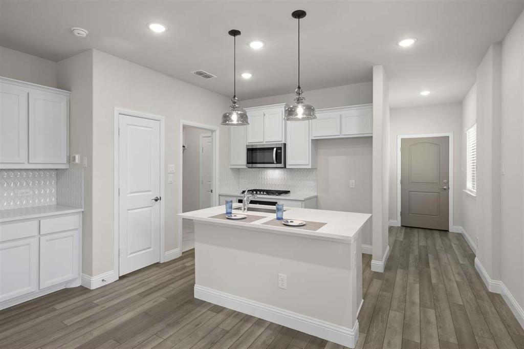 203 Griffith Drive Princeton, TX 75407 - Photo 15 of 15 a kitchen that has a lot of counter space and wooden floor
