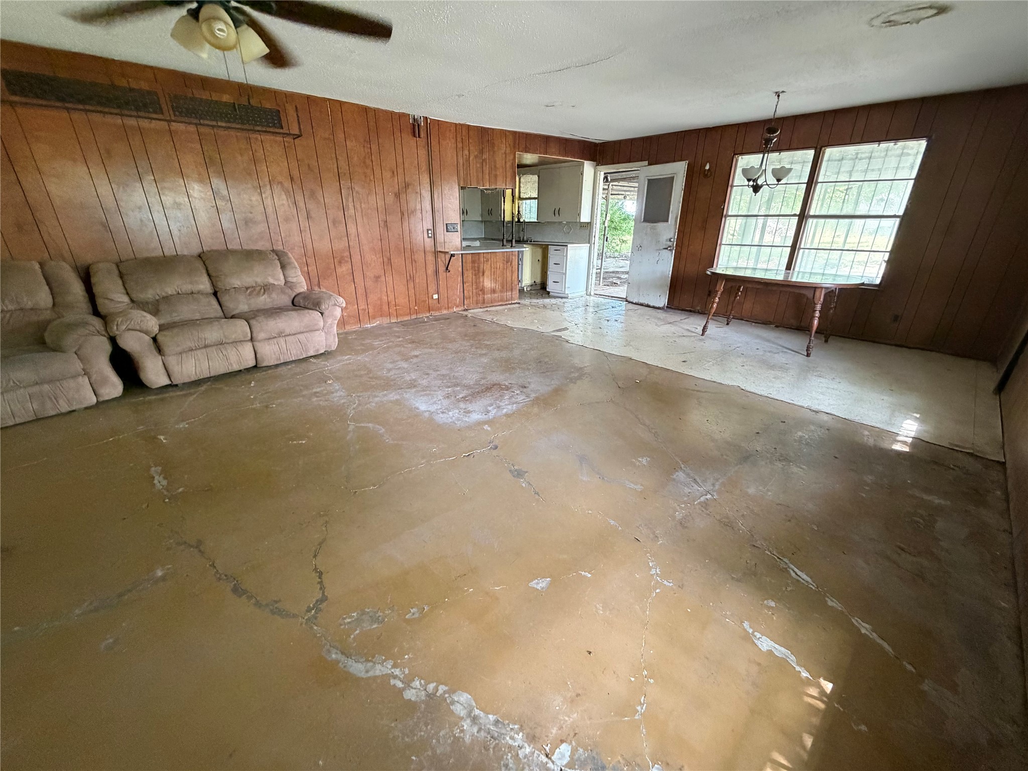2501 Barnhardt Road Temple, TX 76502 - Photo 8 of 25 A spacious room offers ample potential for renovation, with existing paneled walls and a ceiling fan.