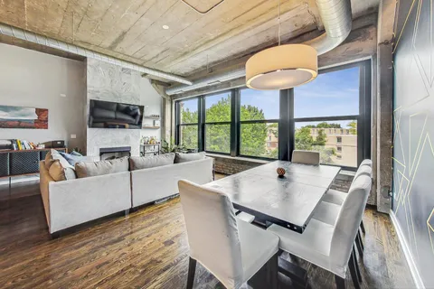 a living room with furniture a flat screen tv and a large window