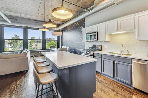 a kitchen with stainless steel appliances granite countertop a sink a stove and a refrigerator