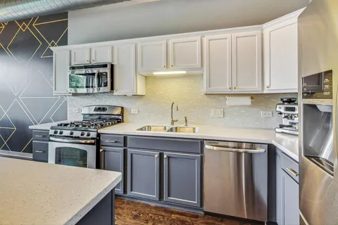 a kitchen with stainless steel appliances granite countertop a stove a sink dishwasher and a refrigerator