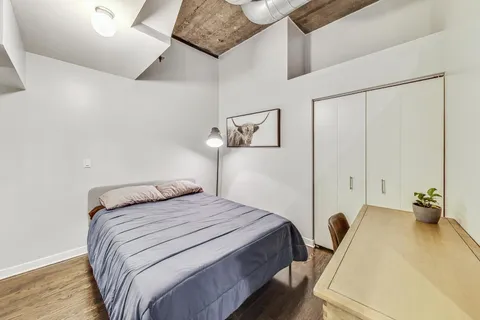 a bedroom with a bed and wooden floor