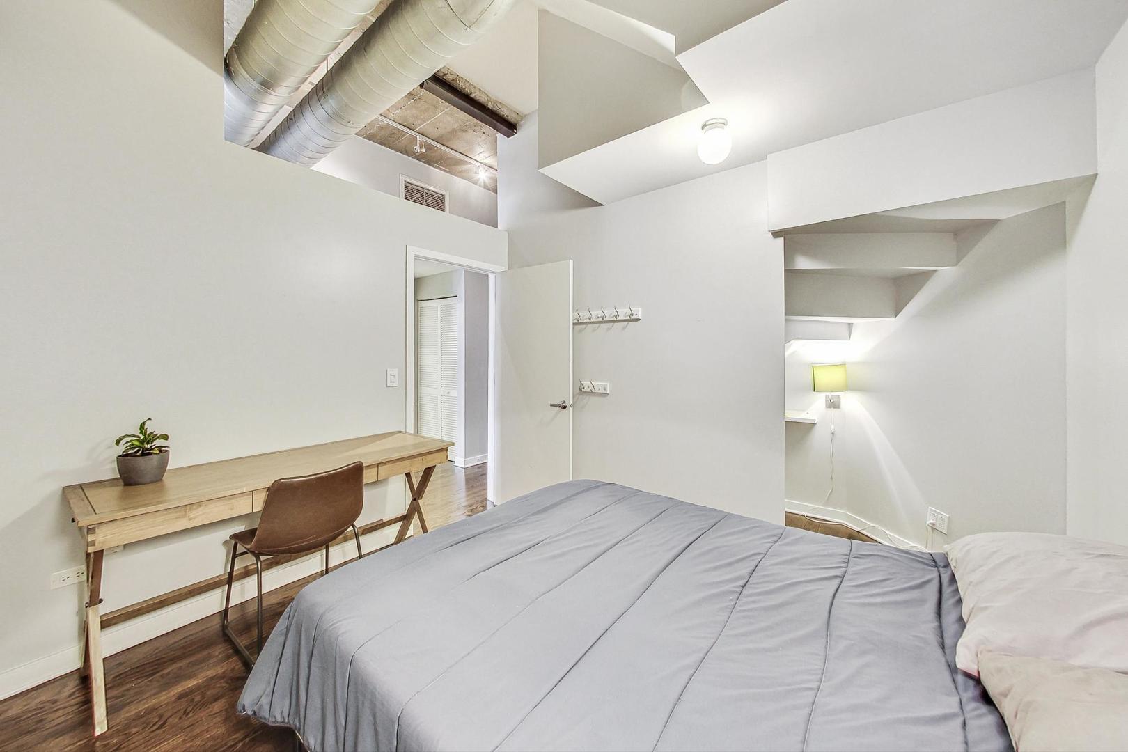 1111 West 14th Place, Unit 328 Chicago, IL 60608 - Photo 27 of 49 a bedroom with a bed and a desk