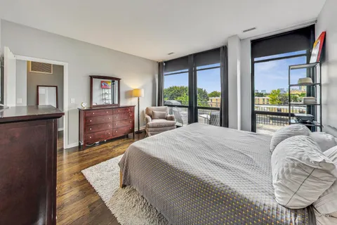 a bed sitting in a bedroom next to a window with a balcony